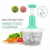 Manual hand food chopper with green lid and stainless steel blades, shown with carrots and lettuce.