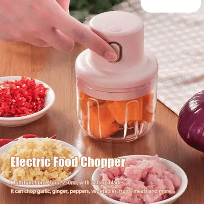 USB rechargeable mini electric food chopper with 250ml bowl, chopping vegetables on kitchen table.
