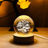 Crystal ball night lamp with Arabic calligraphy on a wooden base, warm ambient lighting.