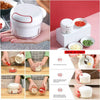 Handheld mini meat grinder and food chopper with manual pull cord, shown blending vegetables.